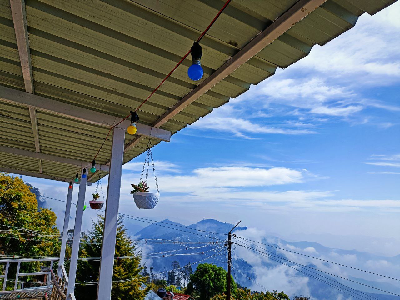 Scenic view of Jenova Homestays cottages in Vattakanal, surrounded by misty mountains
